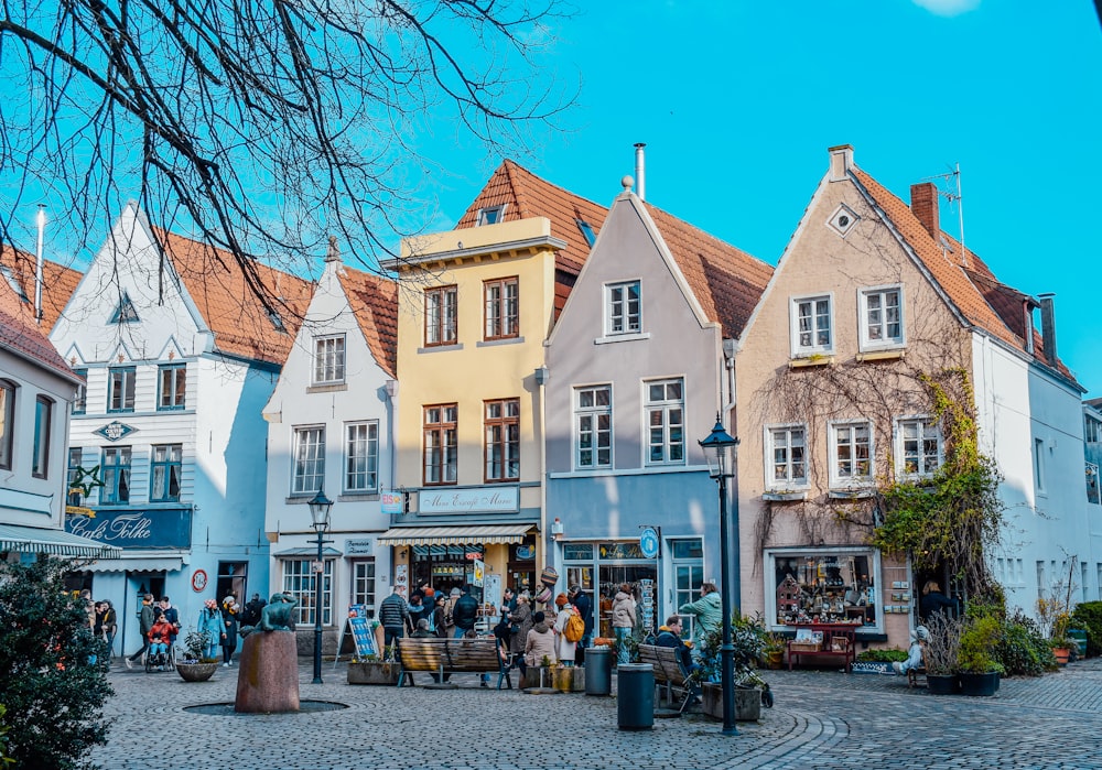 a group of people walking around a cobblestone street