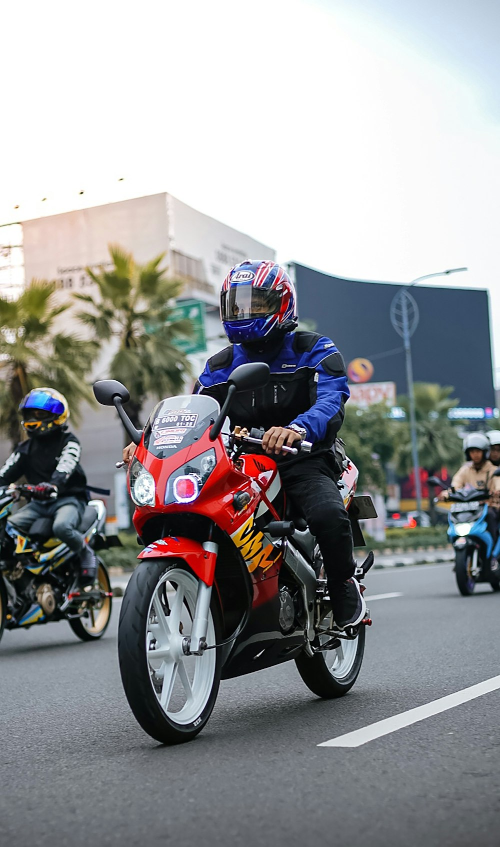 a group of people riding motorcycles down a street