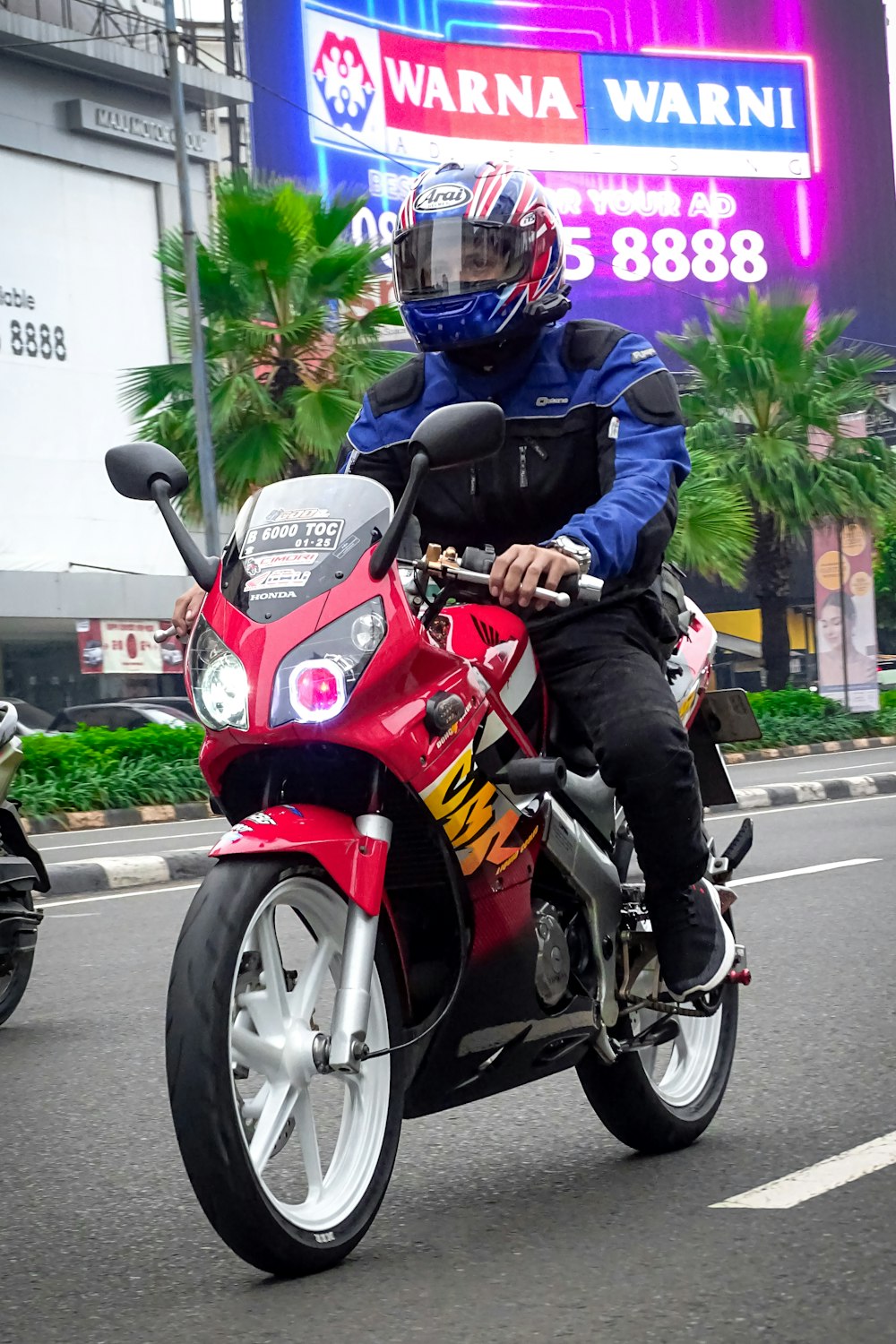 a man riding on the back of a red motorcycle