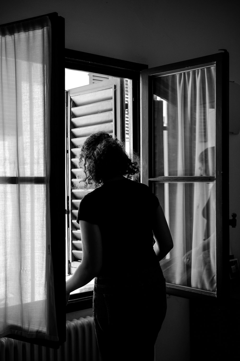 a woman is looking out of a window