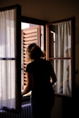 a woman is looking out of a window