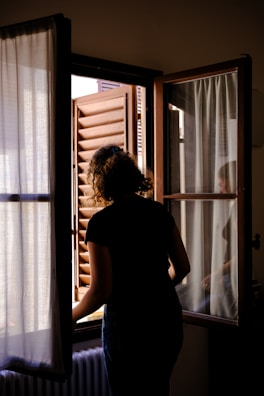 a woman is looking out of a window