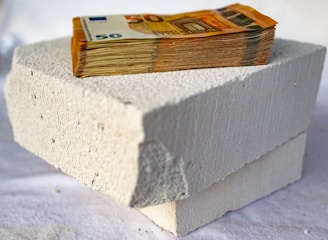 a stack of money sitting on top of a cement block