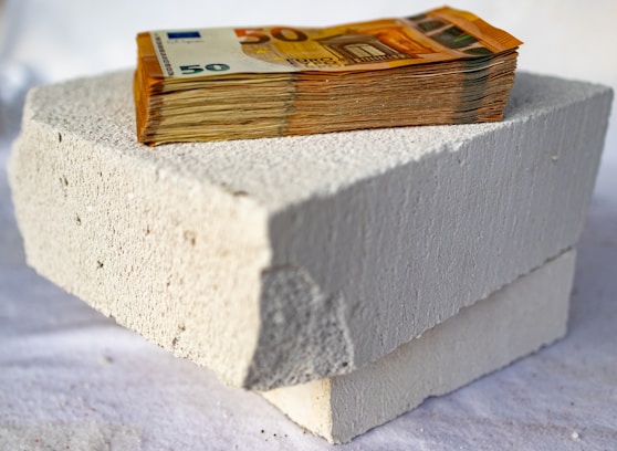 a stack of money sitting on top of a cement block