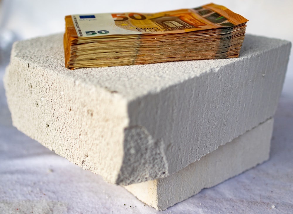 a stack of money sitting on top of a cement block