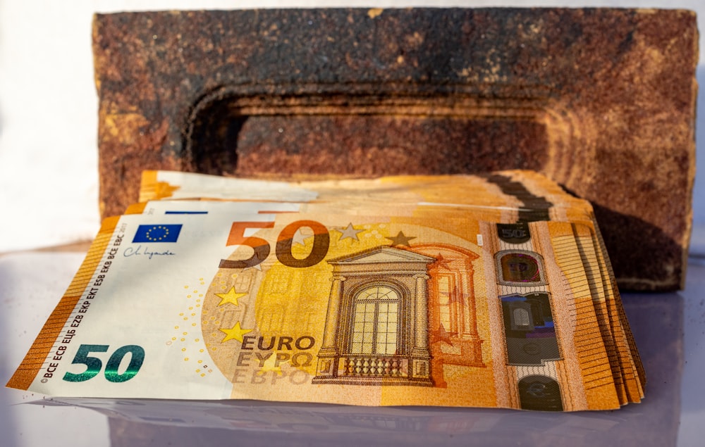 a 50 euro bill sitting next to a wallet