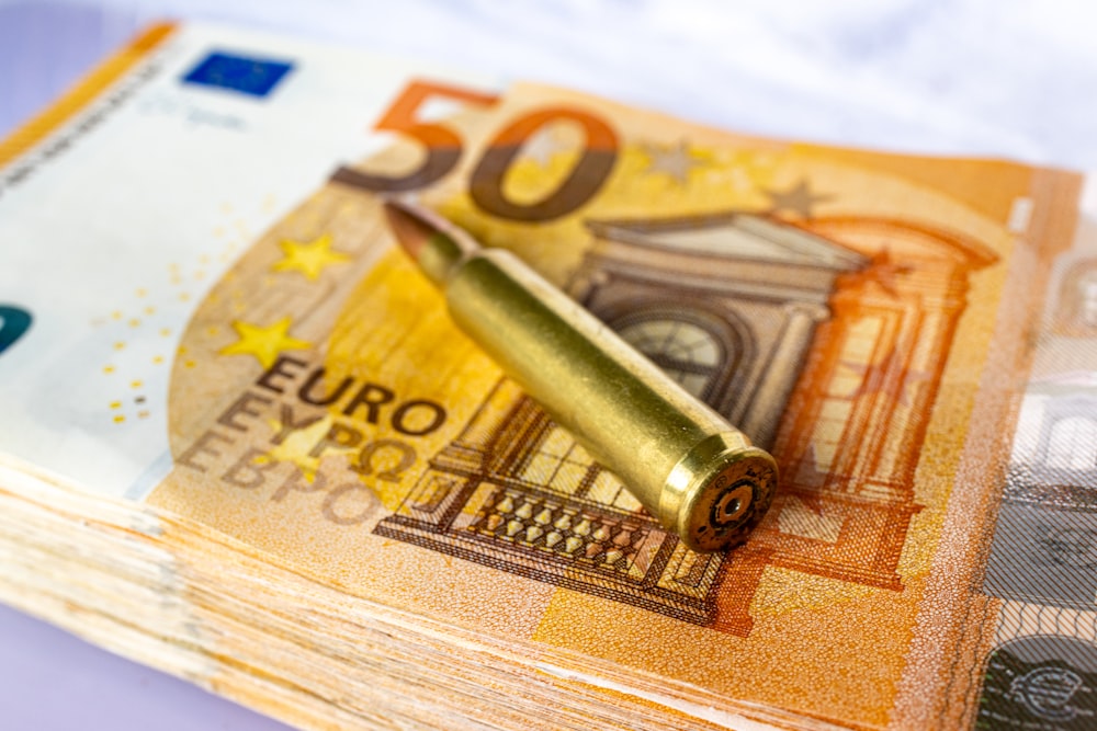 a stack of 50 euro bills with a bullet sticking out of it