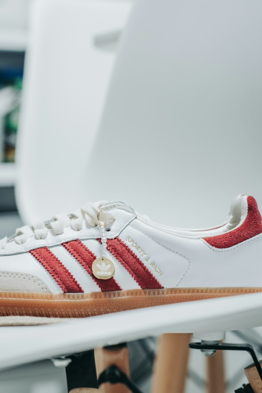 a pair of white and red shoes sitting on top of a white chair