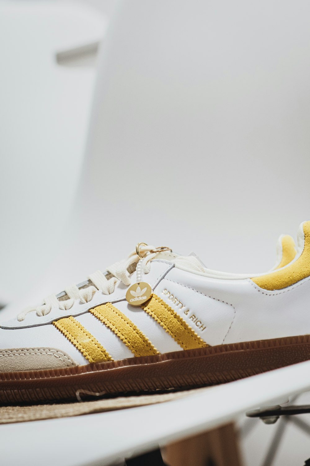 a pair of white and yellow shoes sitting on top of a white chair