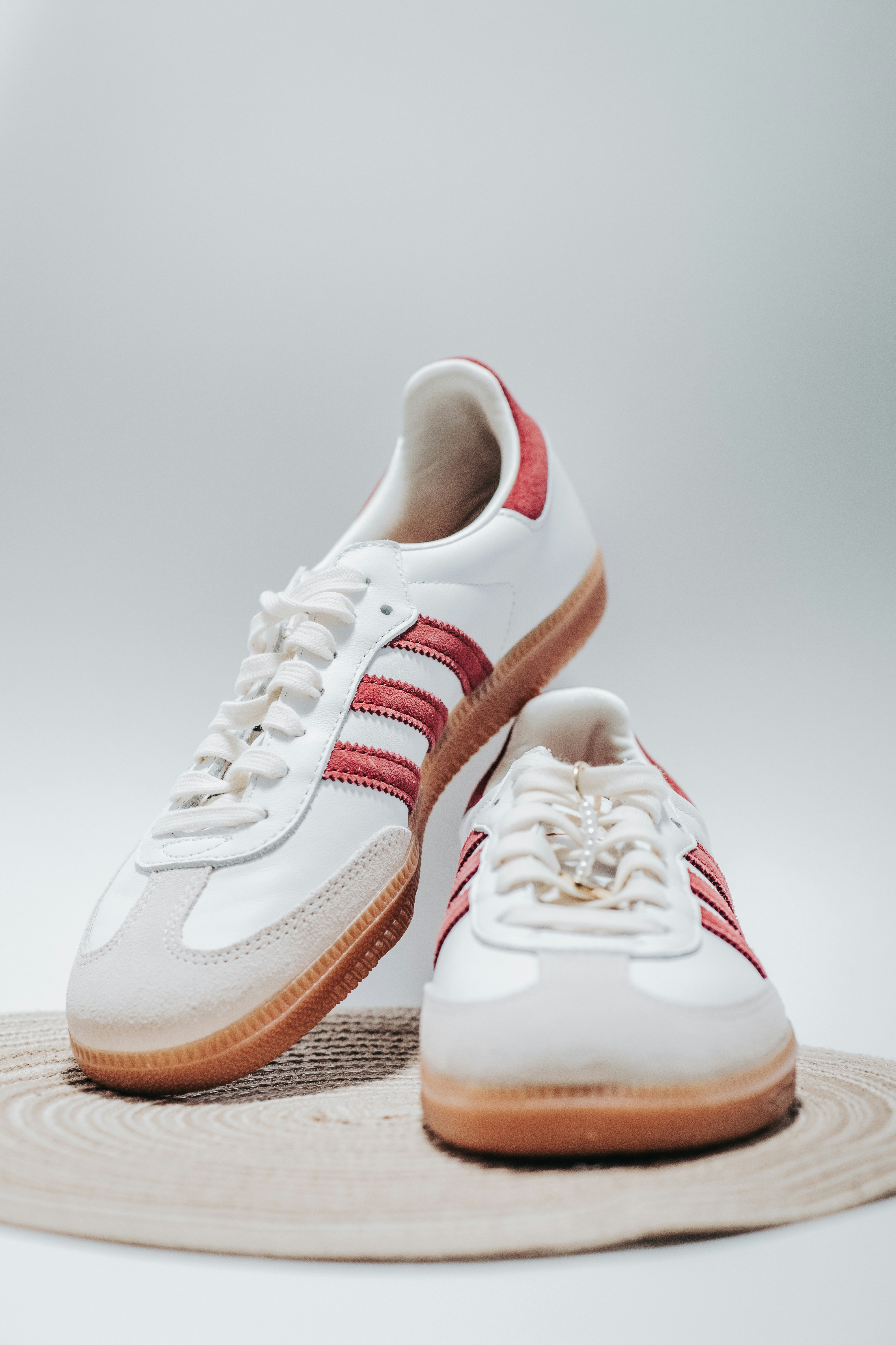 a pair of white and red sneakers sitting on top of a rug