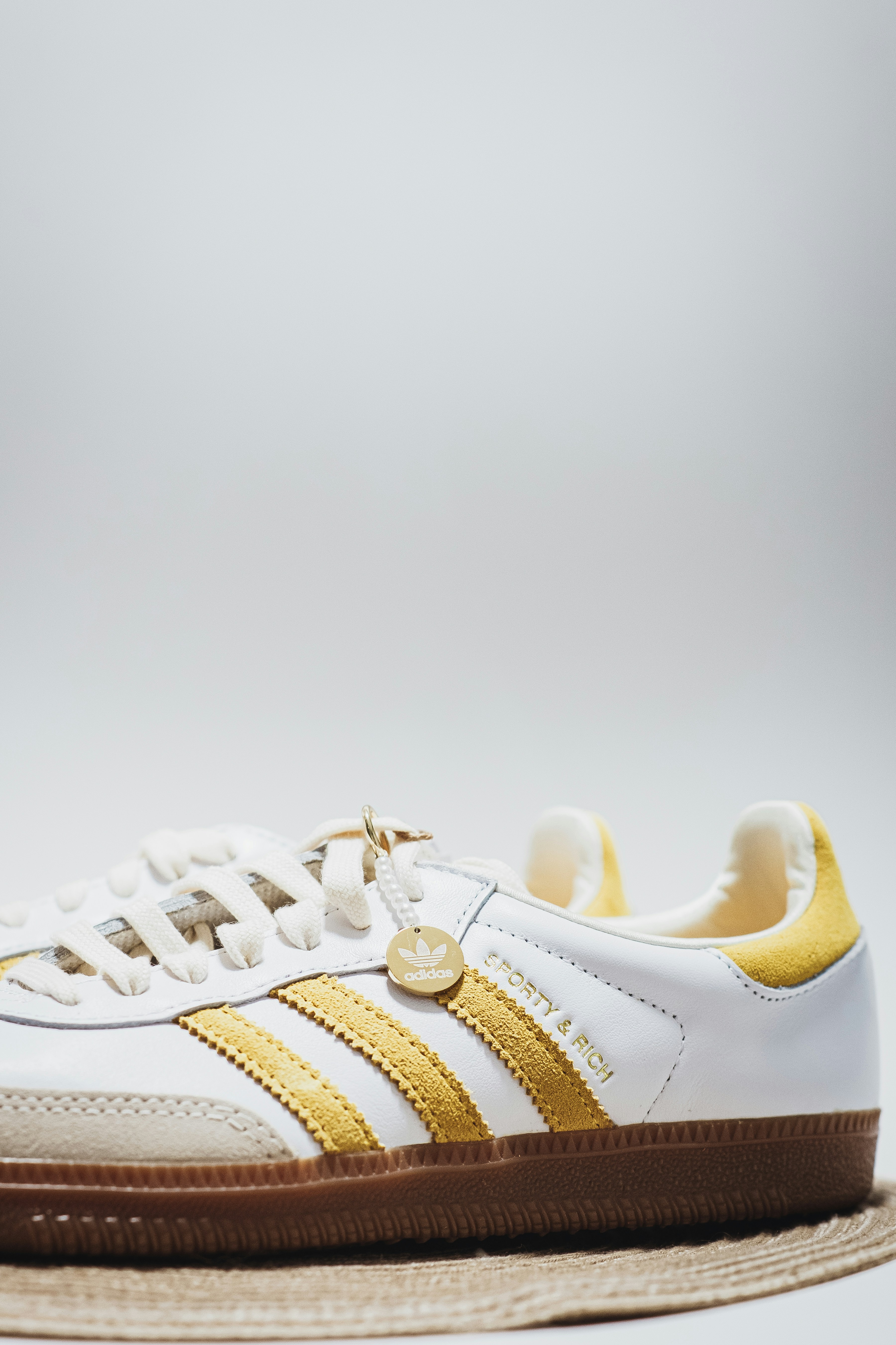 a white and gold sneaker with a brown sole