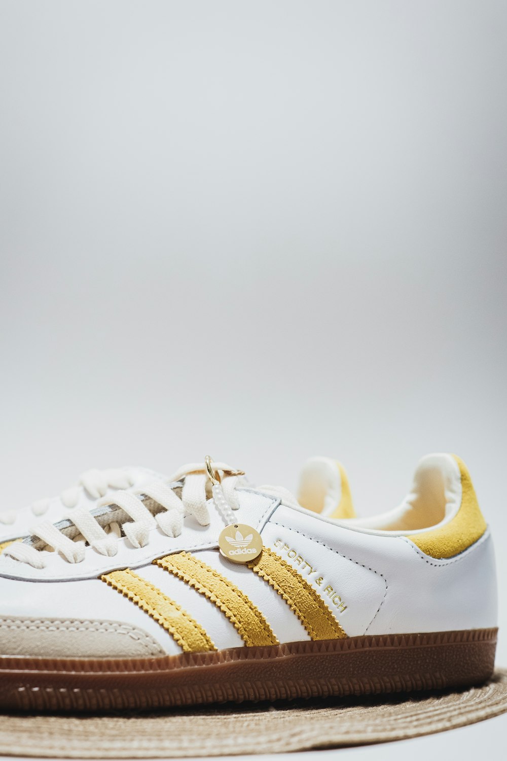 a white and gold sneaker with a brown sole
