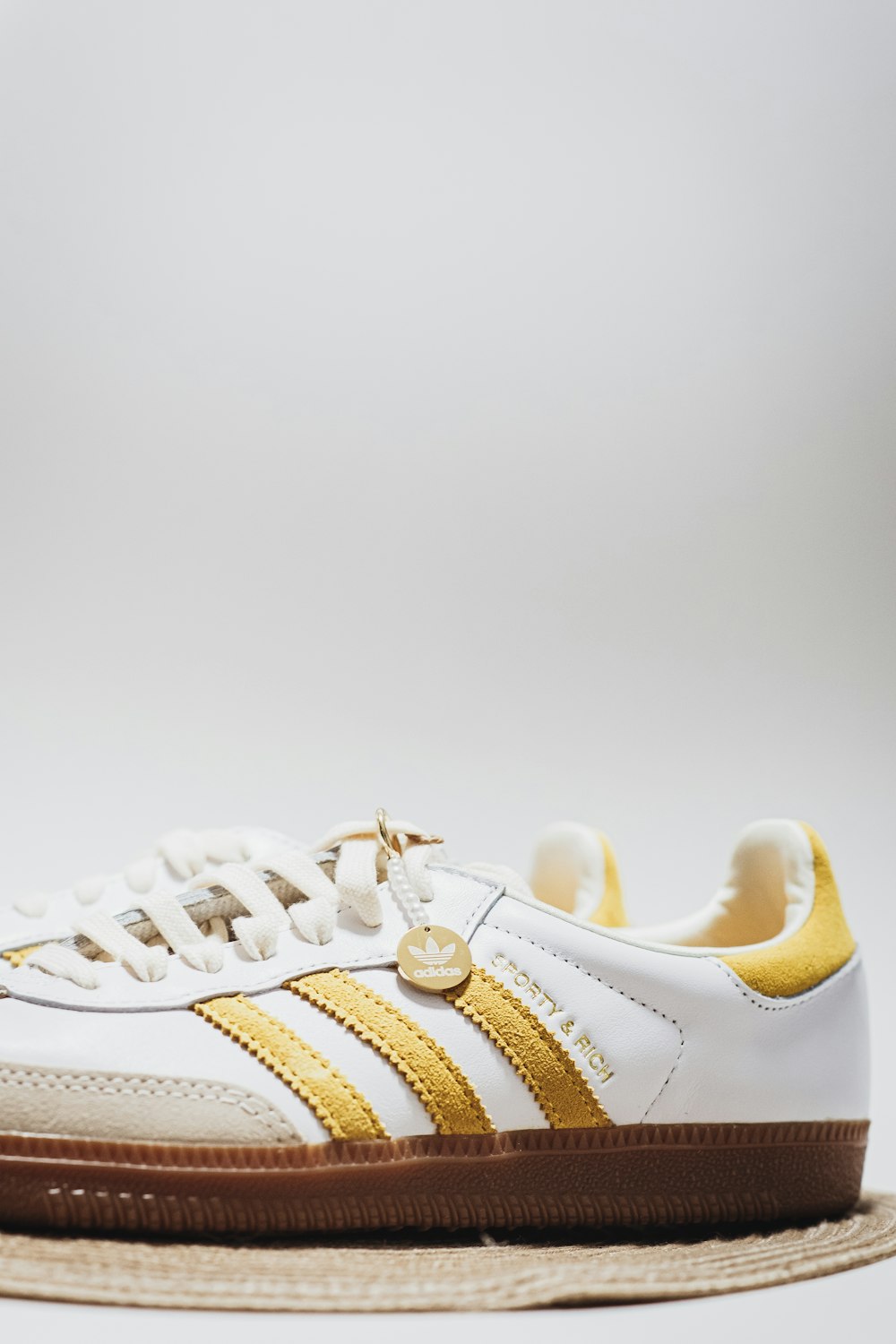 a white and gold sneaker with brown soles