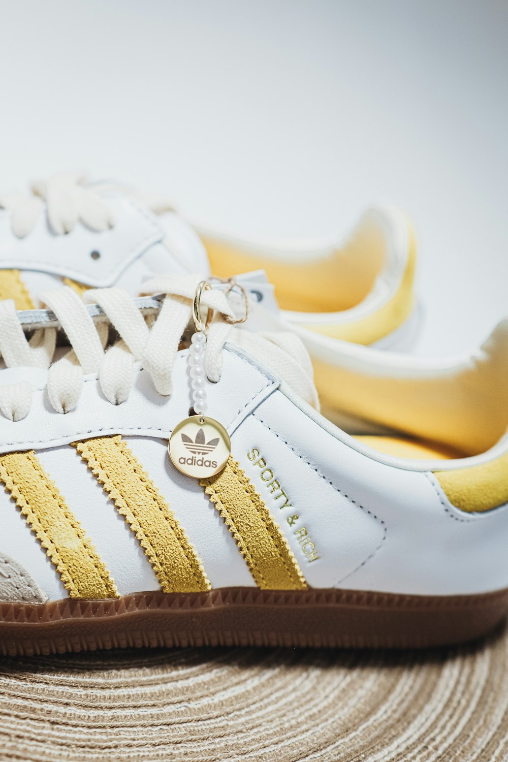 a pair of white and gold adidas sneakers