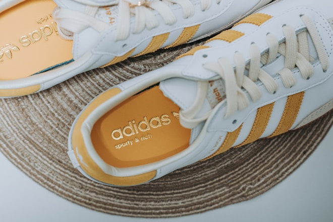 a pair of white and yellow adidas sneakers