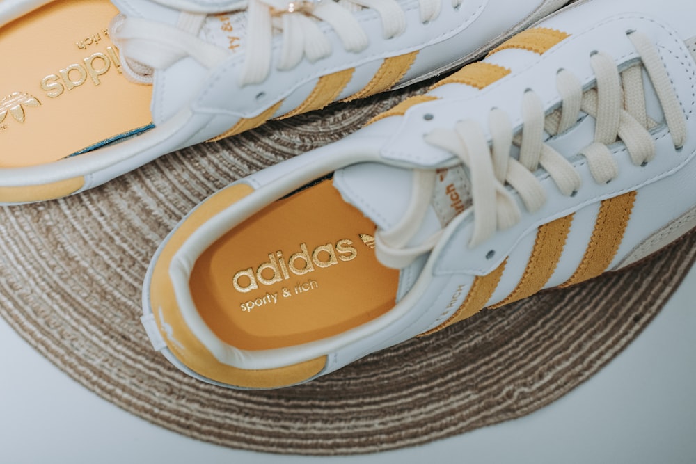 a pair of white and yellow adidas sneakers