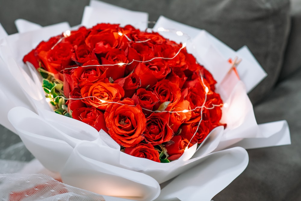 a bouquet of red roses wrapped in white paper