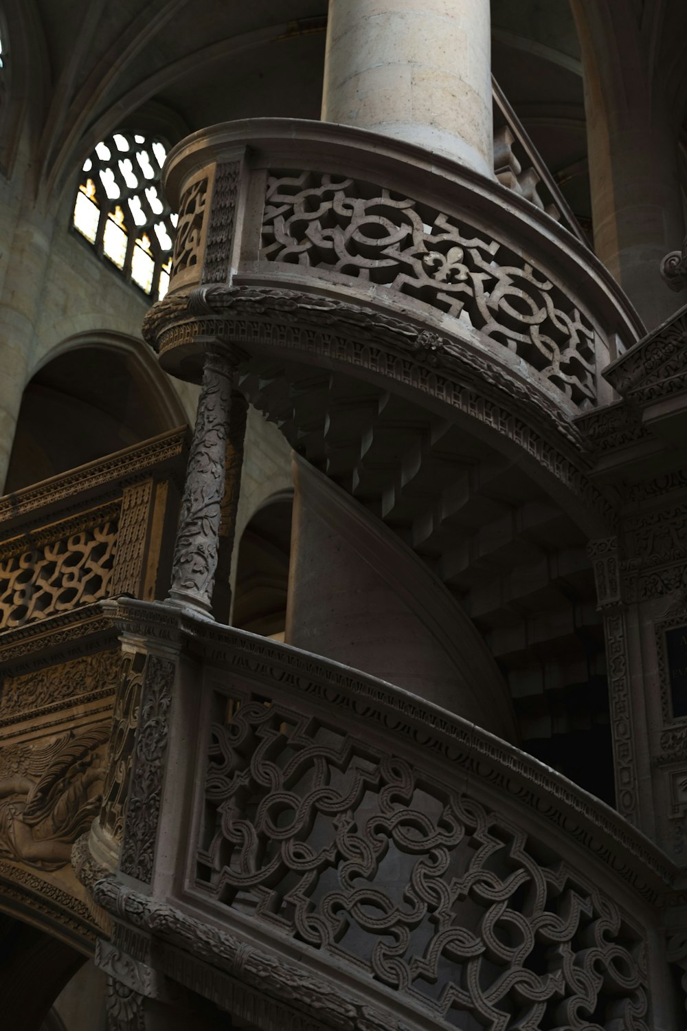 a spiral staircase in a building with a window in the background