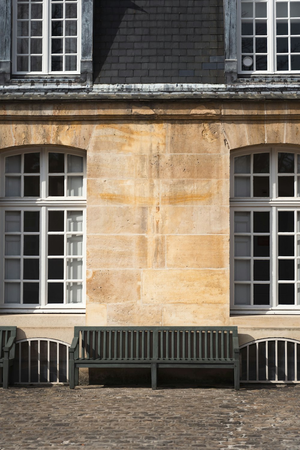 a couple of green benches sitting in front of a building