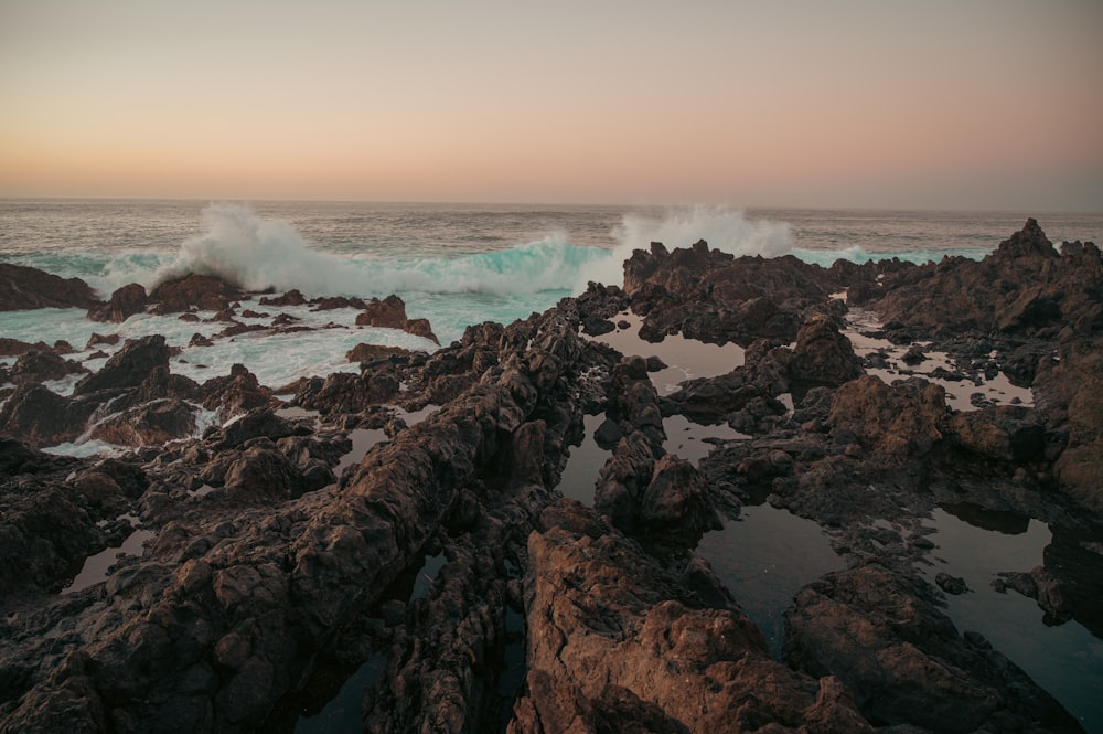 a large body of water sitting next to a rocky shore