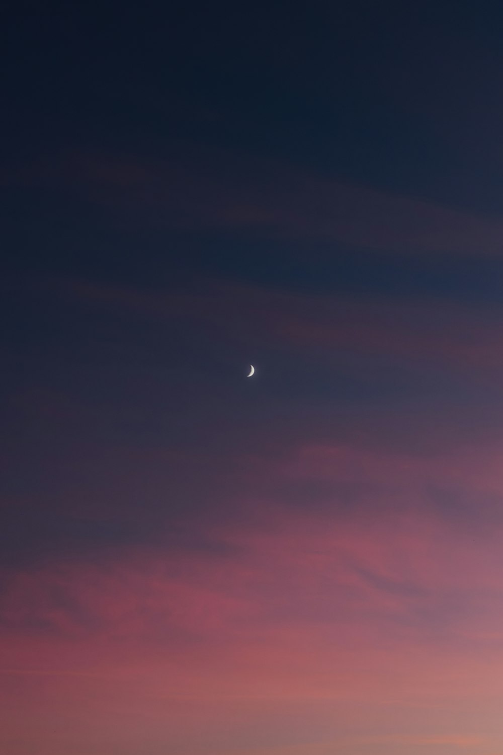 a plane flying in the sky at sunset