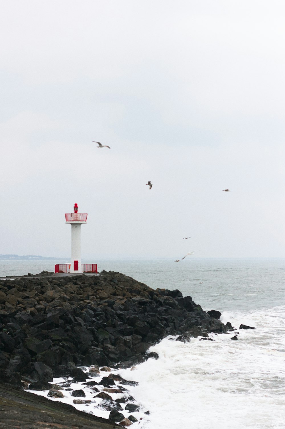 a light house sitting on top of a rocky beach