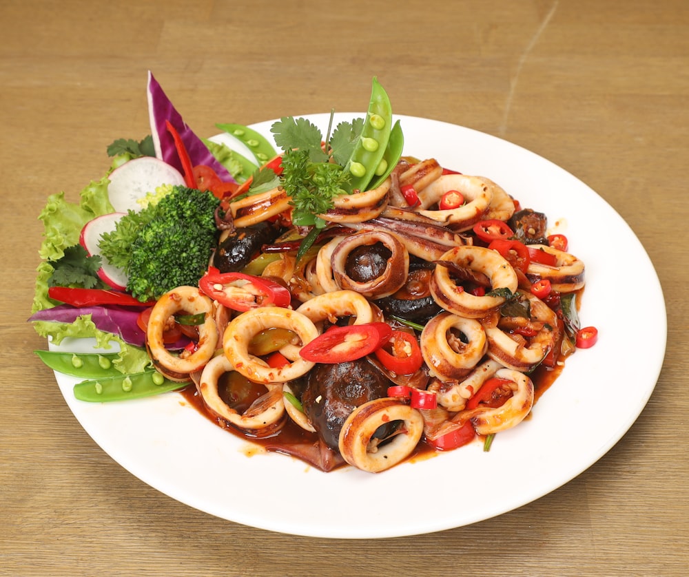 a white plate topped with lots of food on top of a wooden table