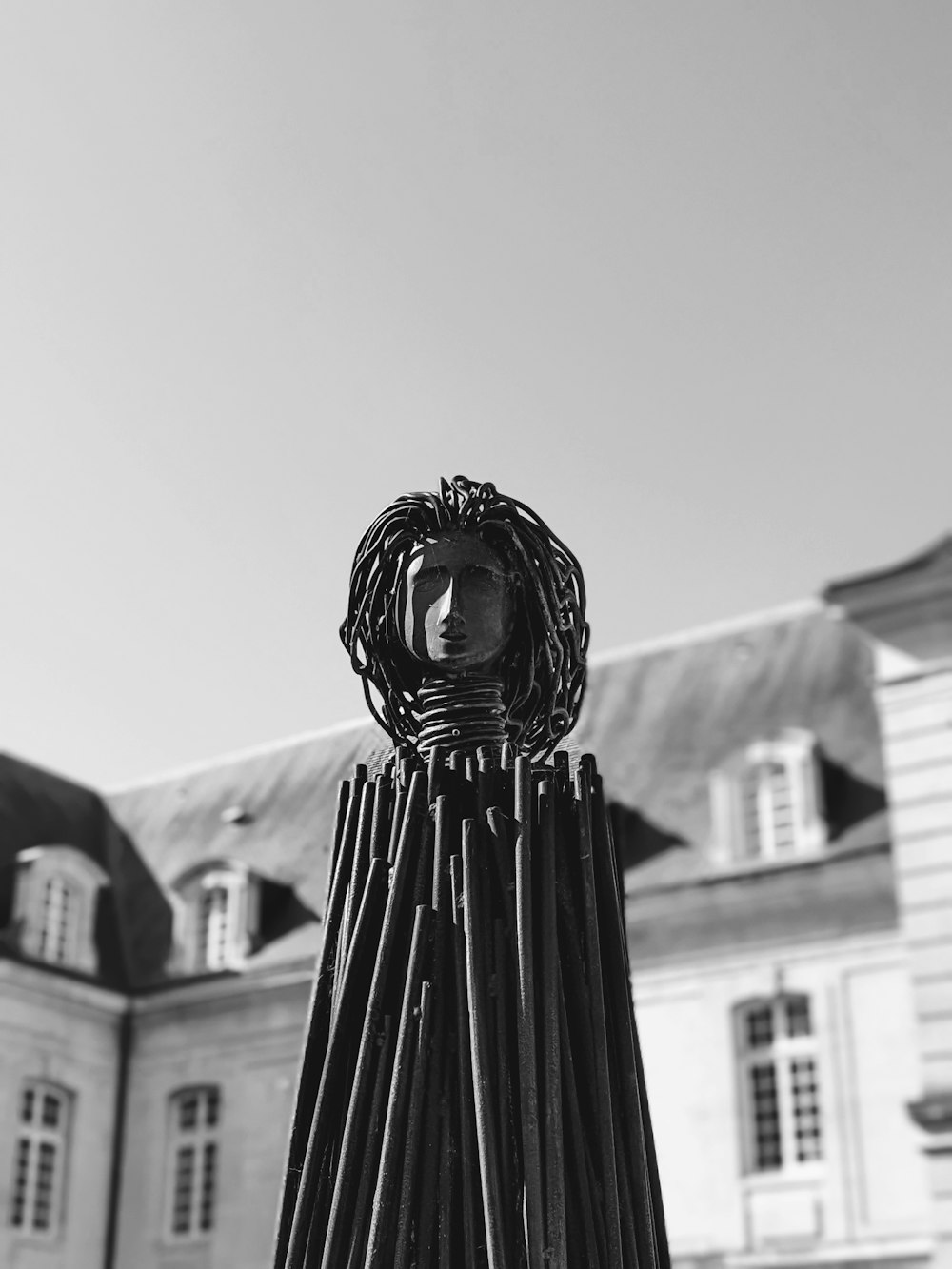 uma foto em preto e branco de uma escultura em frente a um edifício