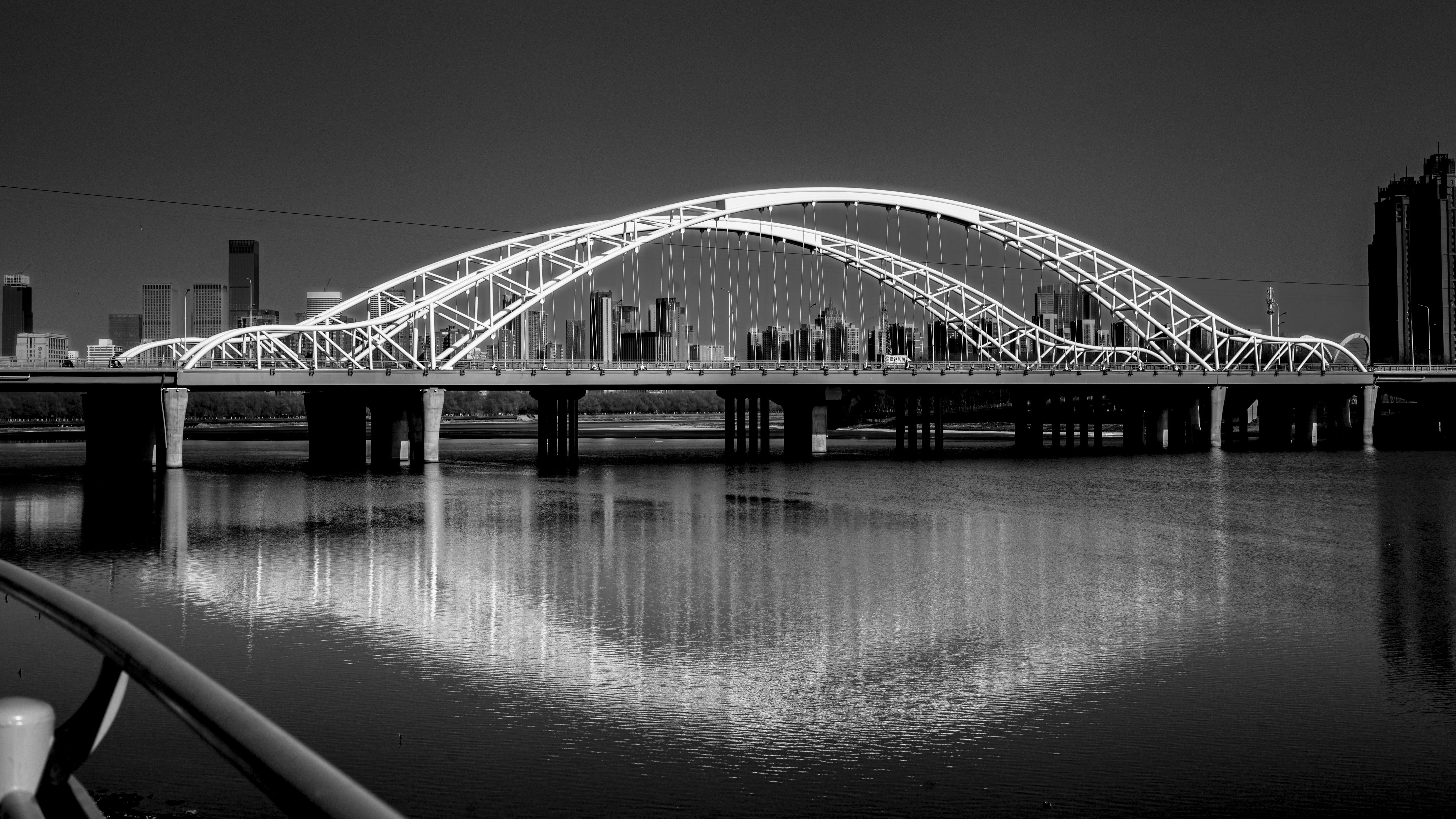 a black and white photo of a bridge over water
