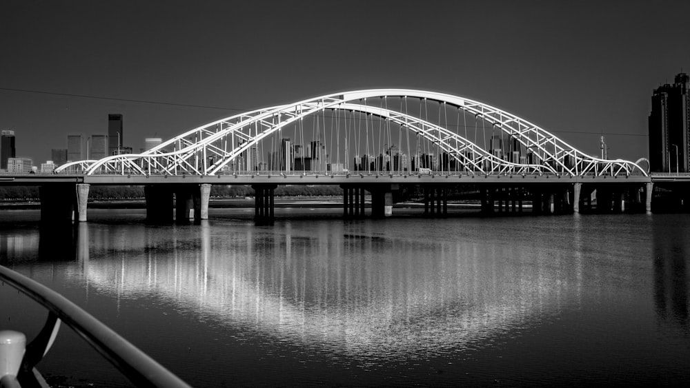 a black and white photo of a bridge over water