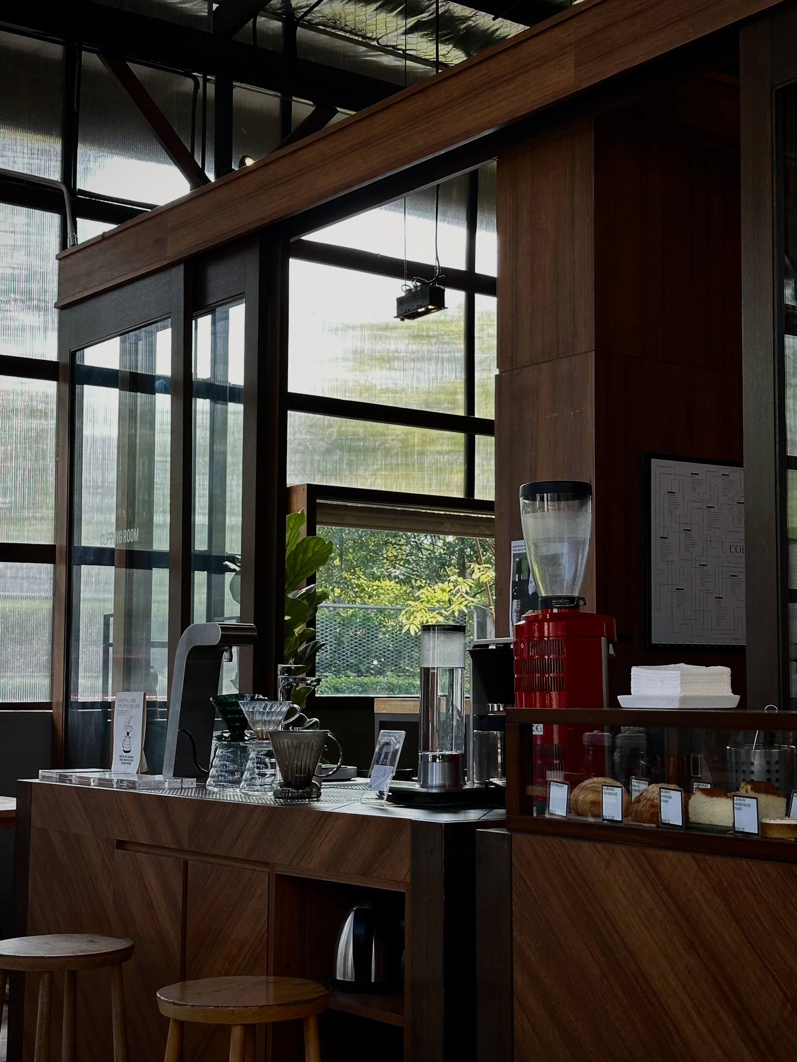 Coffee bar counter with espresso machine, grinders and pastries behind the bar