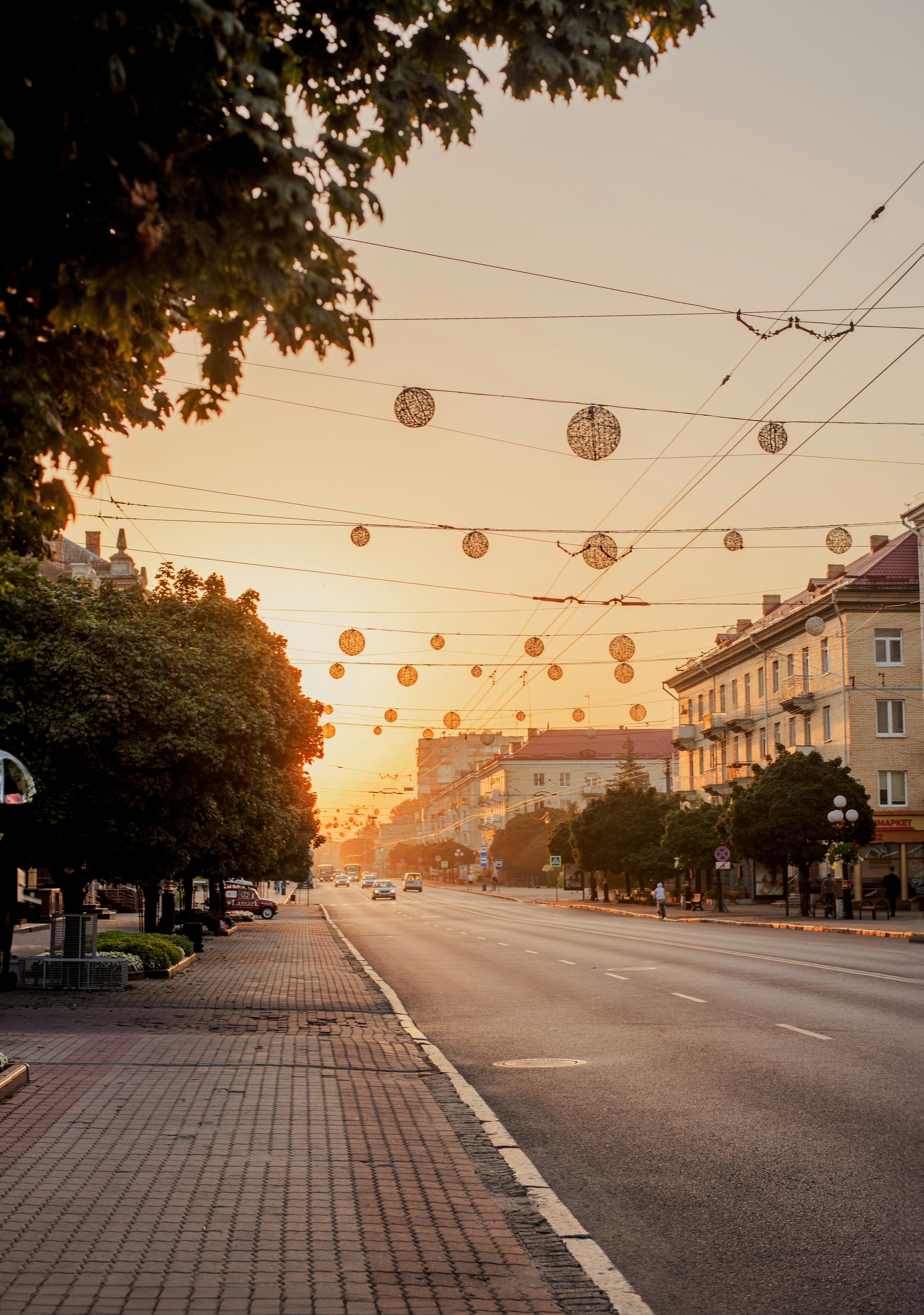 the sun is setting over a city street