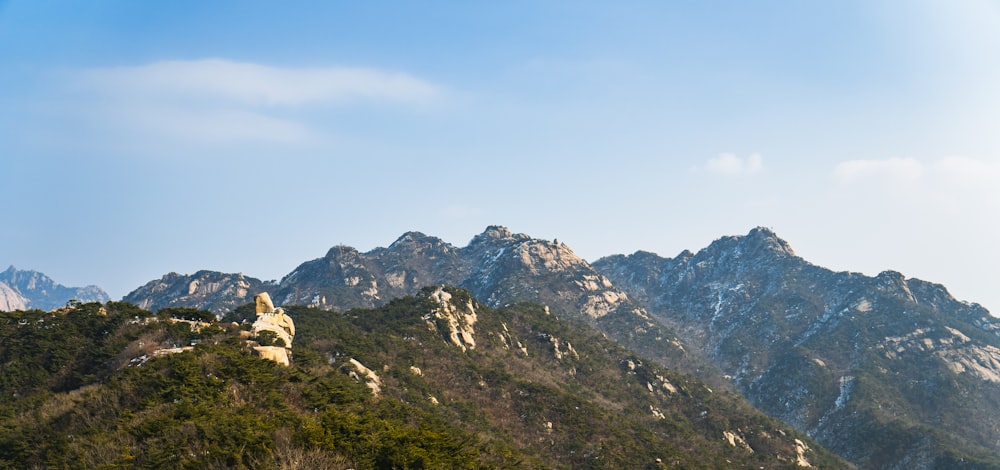 a view of a mountain range from the top of a hill