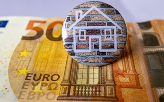 a button sitting on top of a pile of money