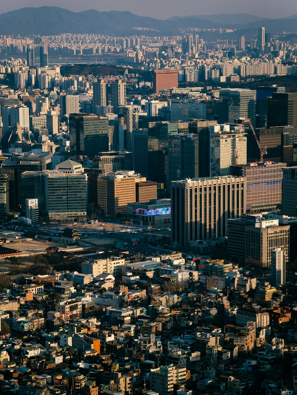 a view of a city with tall buildings and mountains in the background