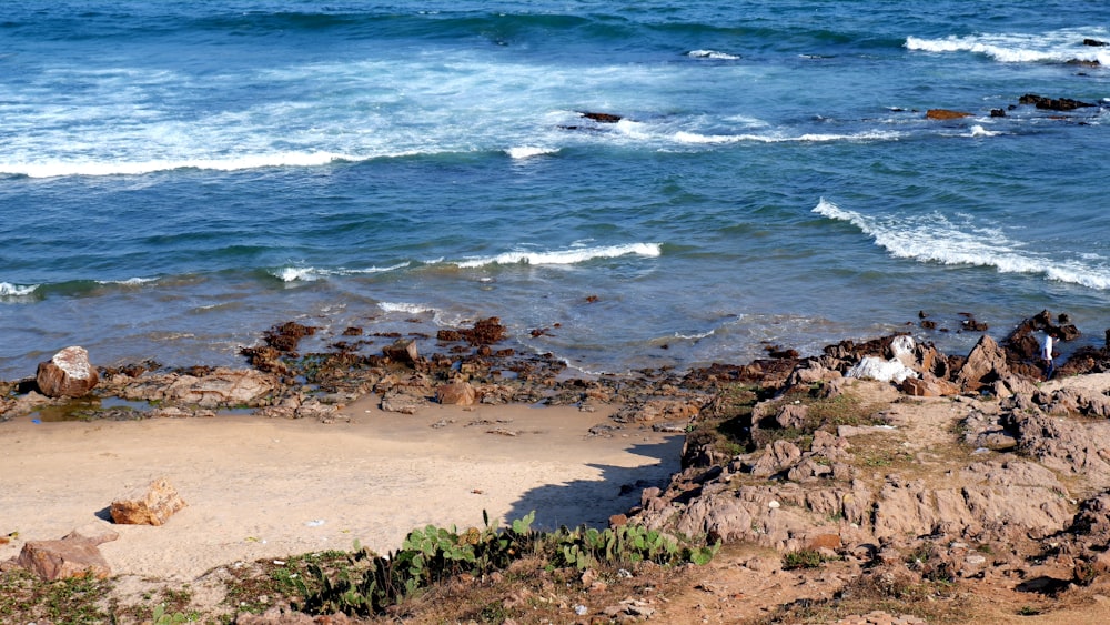 a rocky beach with waves crashing in to shore