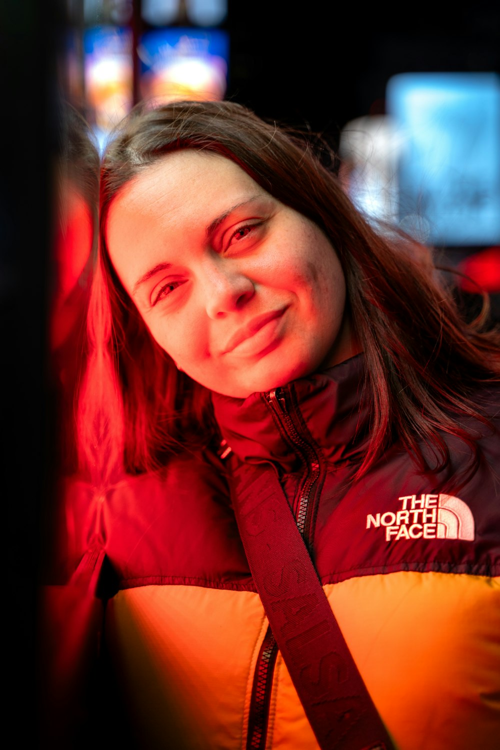 a woman with long hair wearing a red and yellow jacket