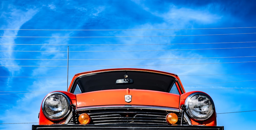 an orange car is parked on the back of a truck