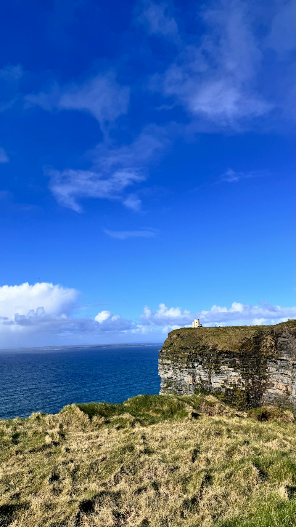 a bench sitting on the side of a cliff overlooking the ocean