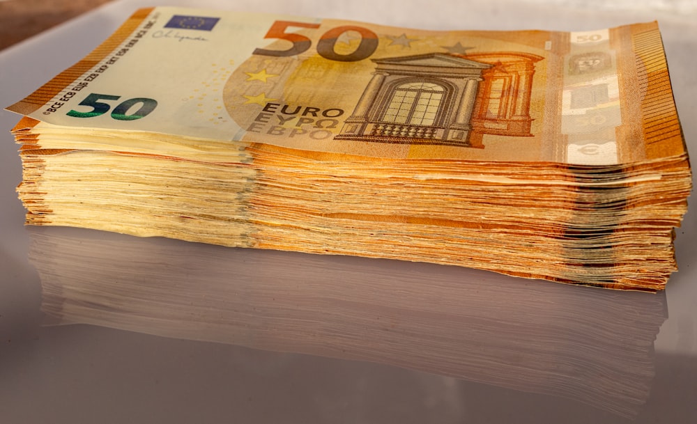 a stack of 50 euro bills sitting on top of a table