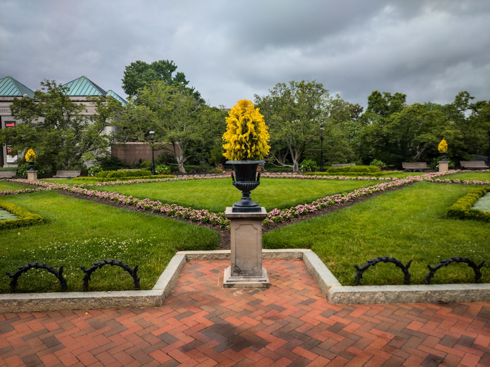 a view of a garden with a statue and flowers in the center