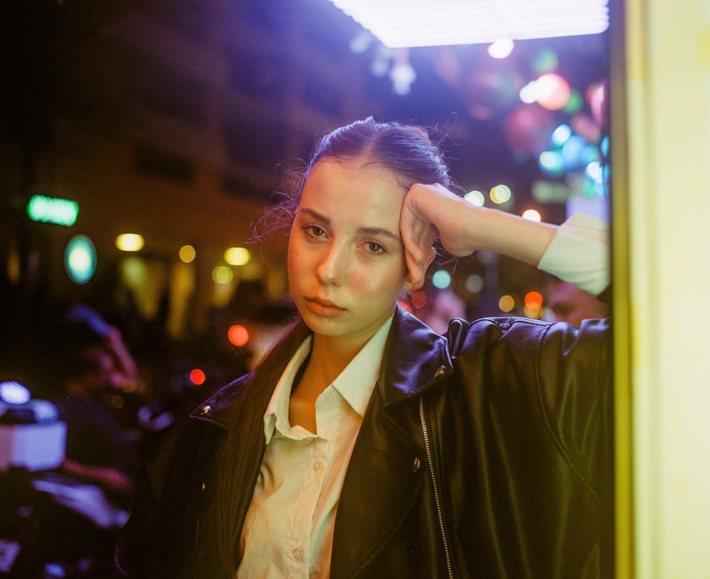 a woman in a white shirt and a black leather jacket