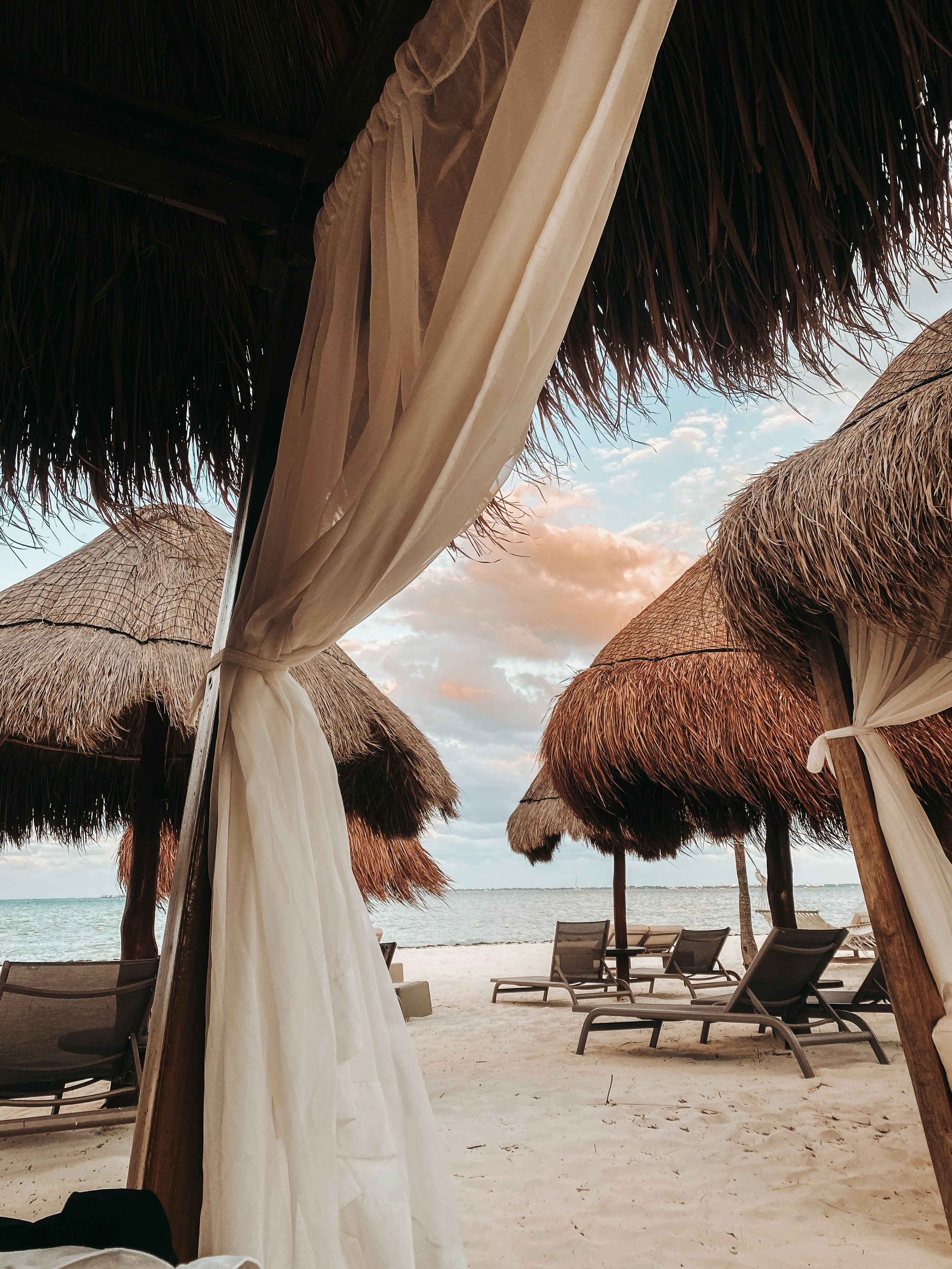 a beach covered in straw umbrellas and chairs