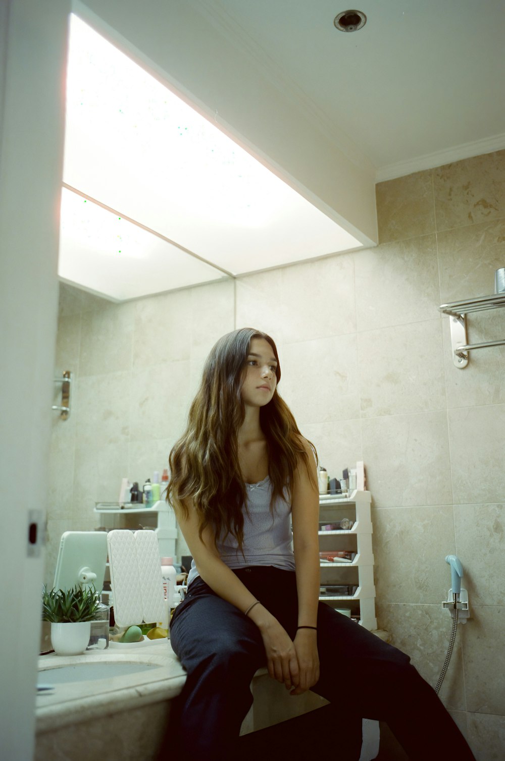 a woman sitting on a counter in a bathroom