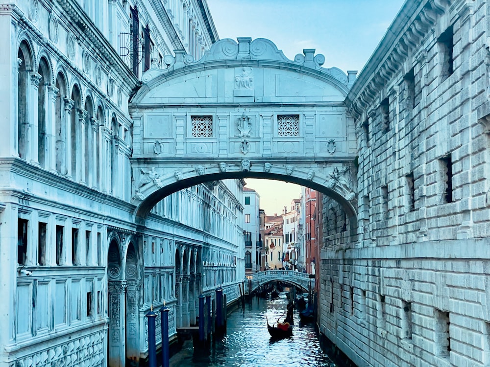 a bridge over a canal with a boat going under it