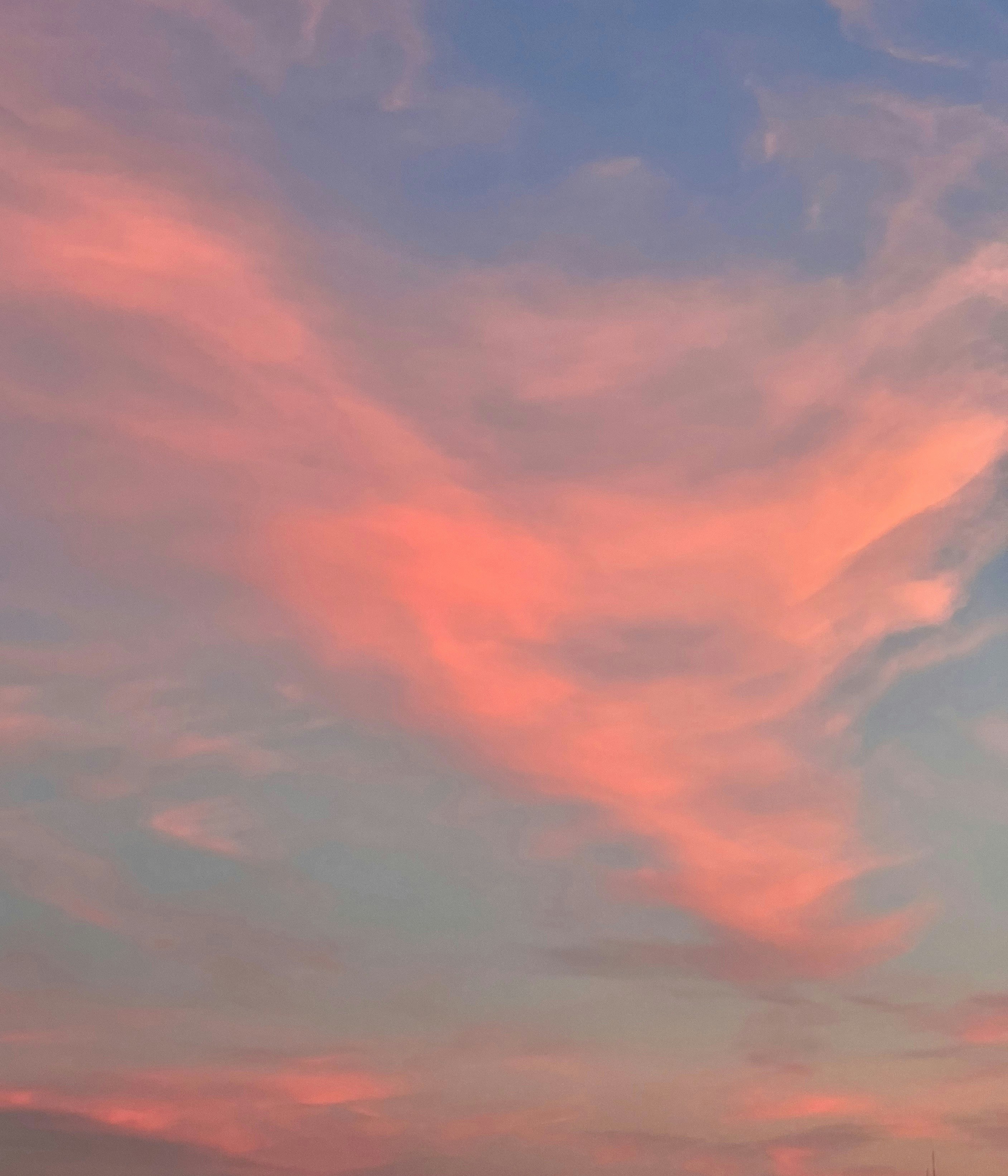 a plane flying in the sky at sunset