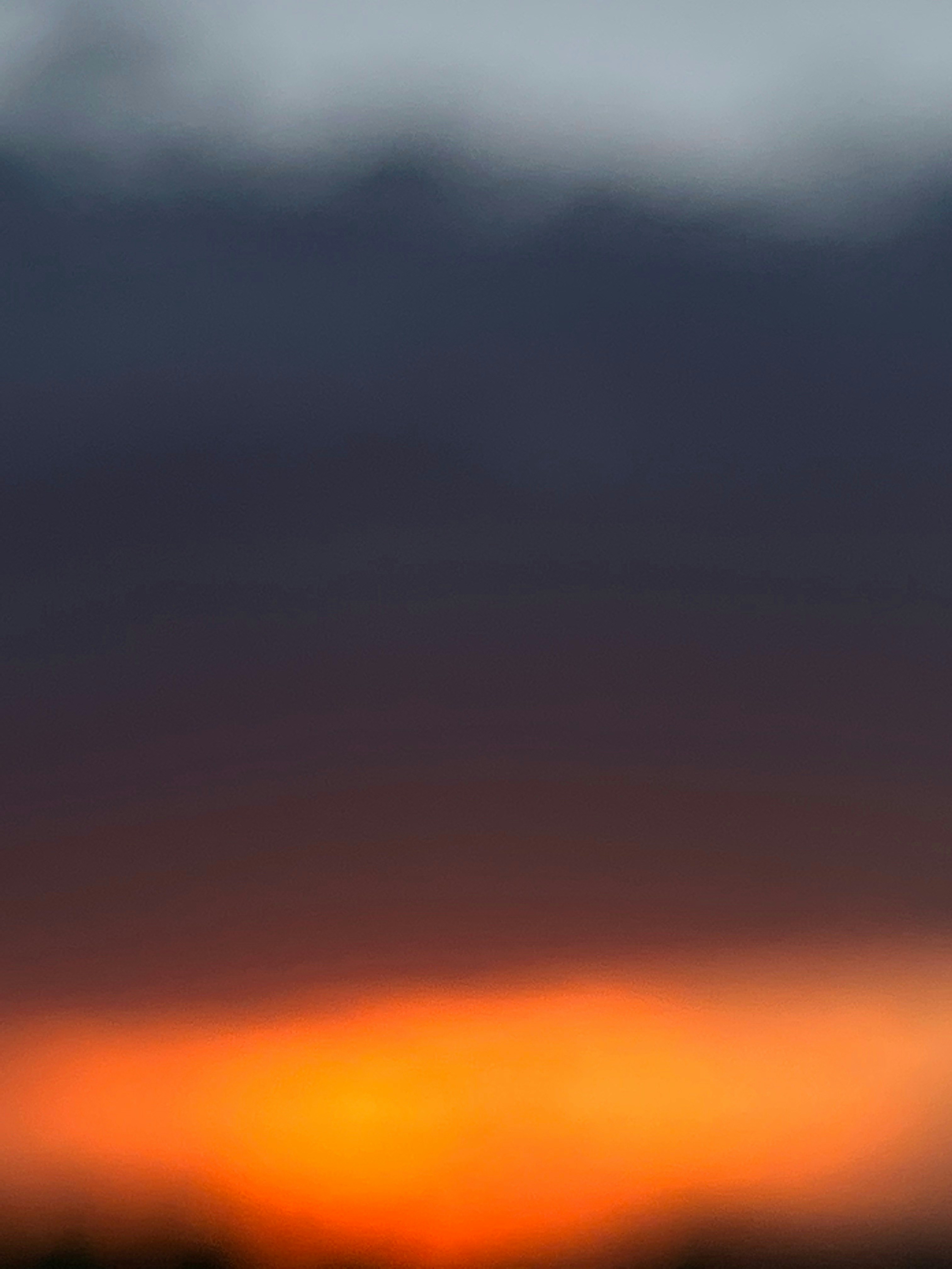 a plane flying in the sky with a sunset in the background