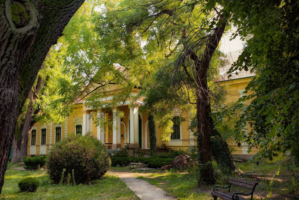 a bench in front of a yellow house