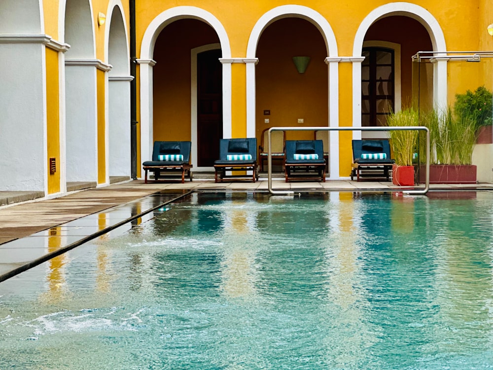 a large swimming pool with lounge chairs next to it