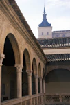a building with arches and a clock tower in the background